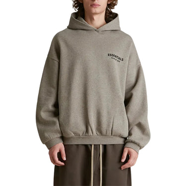 Person wearing a gray hoodie with a brand logo on a white background