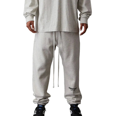 Person wearing gray sweatpants with a brand logo on a white background