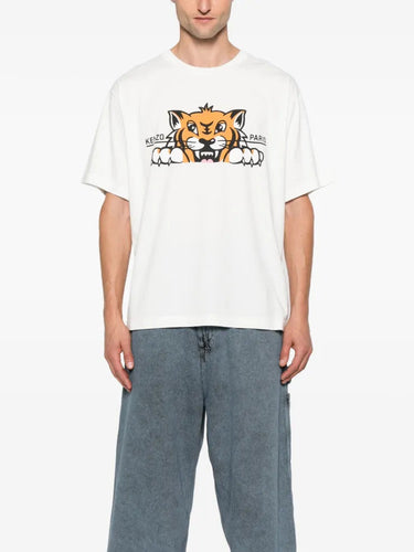 Person wearing a white t-shirt with a graphic design and blue jeans on a white background