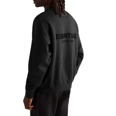 Person wearing a black sweatshirt with 'Essentias' branding on the back, standing against a light gray background.